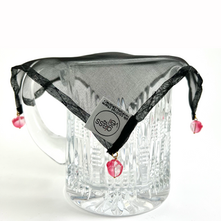 black mulberry silk drink charm draped over a crystal pitcher to guard against bugs and spiking